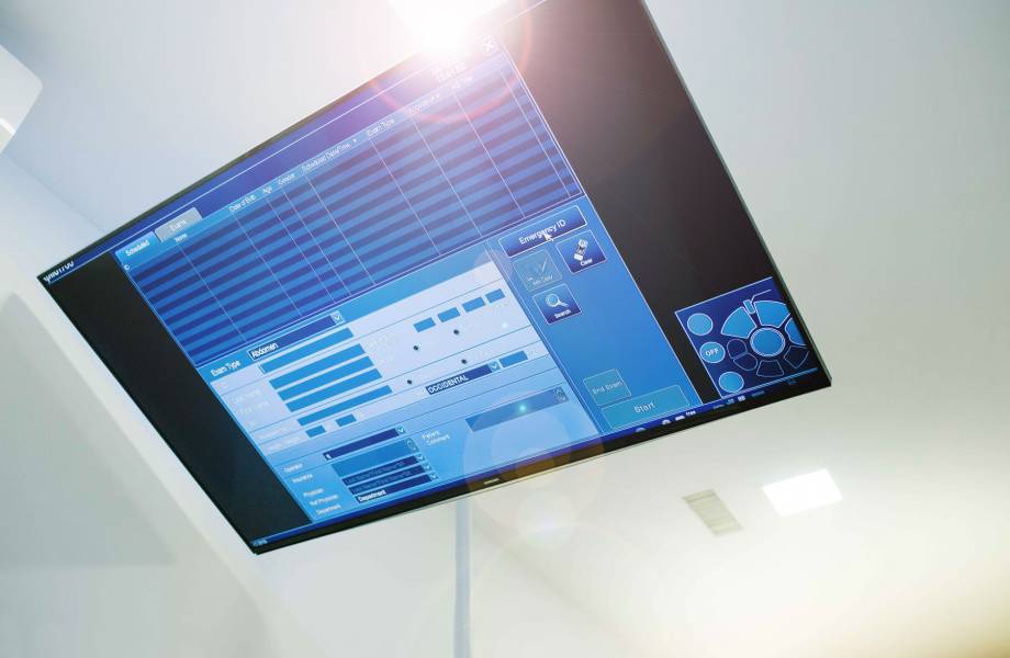 Ein großer, an der Decke befestigter medizinischer Monitor in cleaner Umgebung