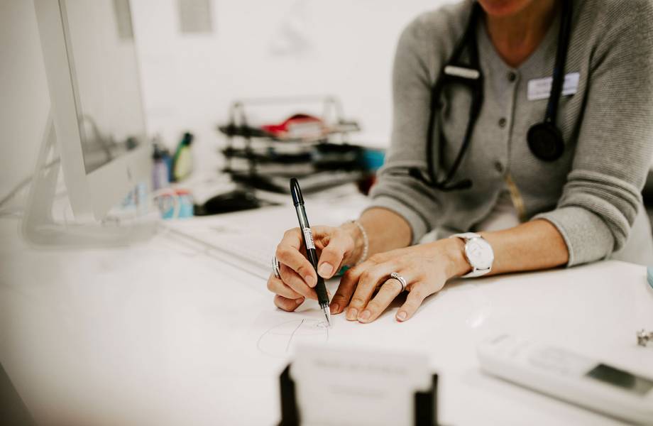 Frau Schüler-Ramos zeichnet einem Patienten etwas auf, was bei der Erklärung des Krankheitsbildes hilft