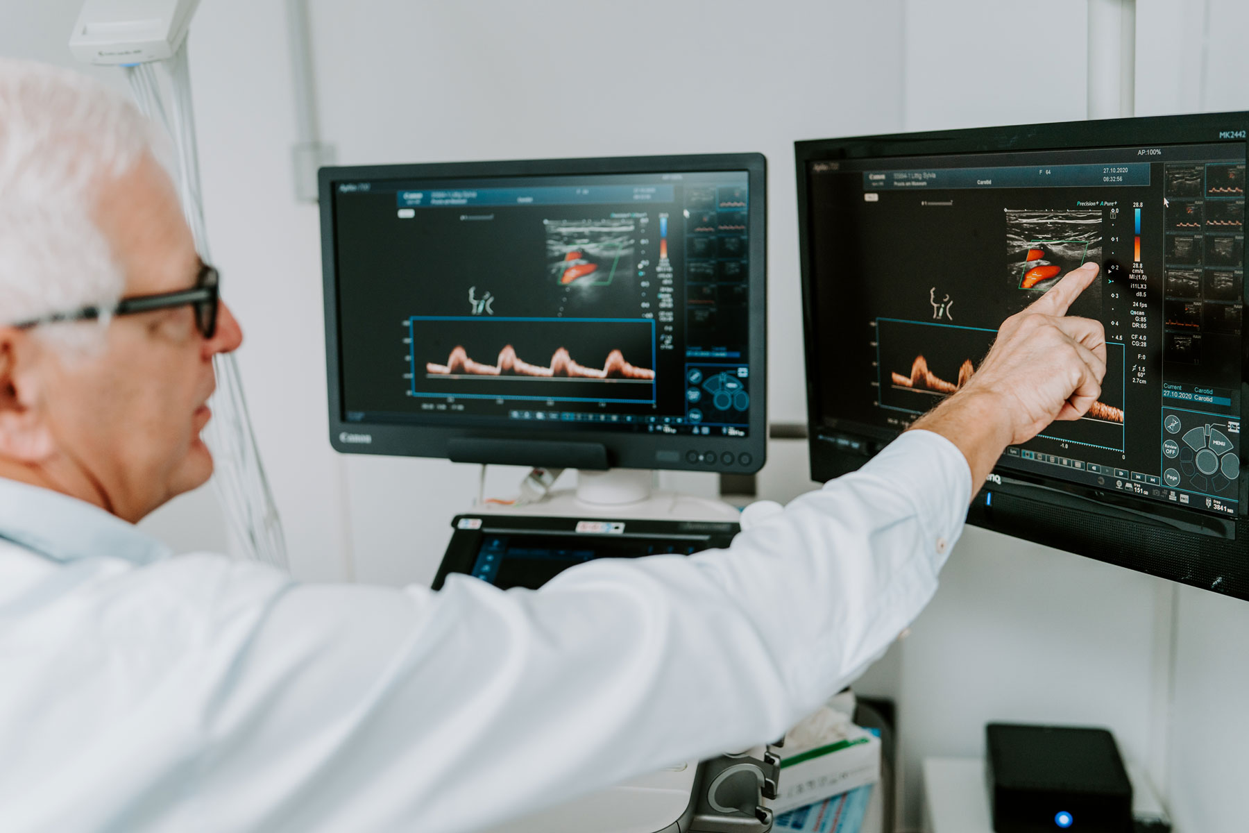 Dr. Listmann zeigt mit dem Finger auf einen Ultraschall-Monitor
